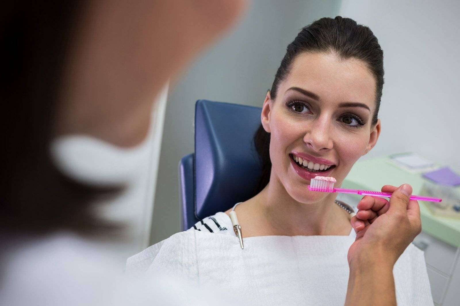 Dentist holding a brush in front of patient at clinic